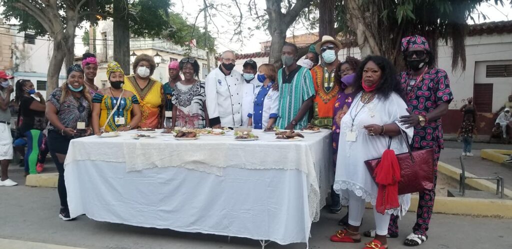 Photo of people getting ready to eat by a table full of food.