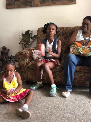 Martiza López McBean, coordinator of the Red Barrial Afrodescendiente, sits with my daughters in sculptor Margarita Montalvo’s home. Photo by Cindy García, 2019. -- Martiza López McBean, coordinadora de la Red Barrial Afrodescendiente, sentada con mis hijas en casa de la escultora Margarita Montalvo. Foto de Cindy García, 2019.