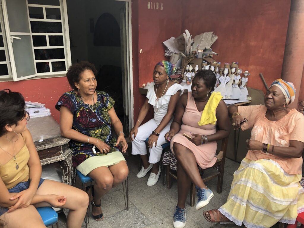 Photo of Professor Danzie sitting with some students.