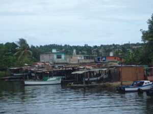 Photograph of seaside shacks and boats.