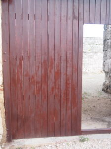 Photograph of a stained wooden slats and a doorway. doorwa