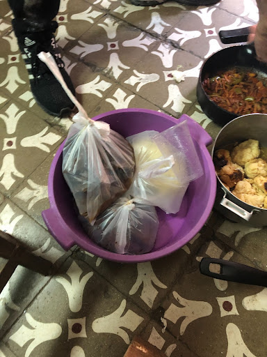 Photograph of bagged up food in a bucket and pots.