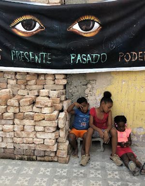 Photograph of children underneath a banner.