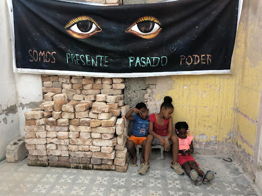 Photograph of children underneath a banner.
