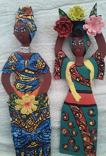 Photograph of two papel maché dolls.