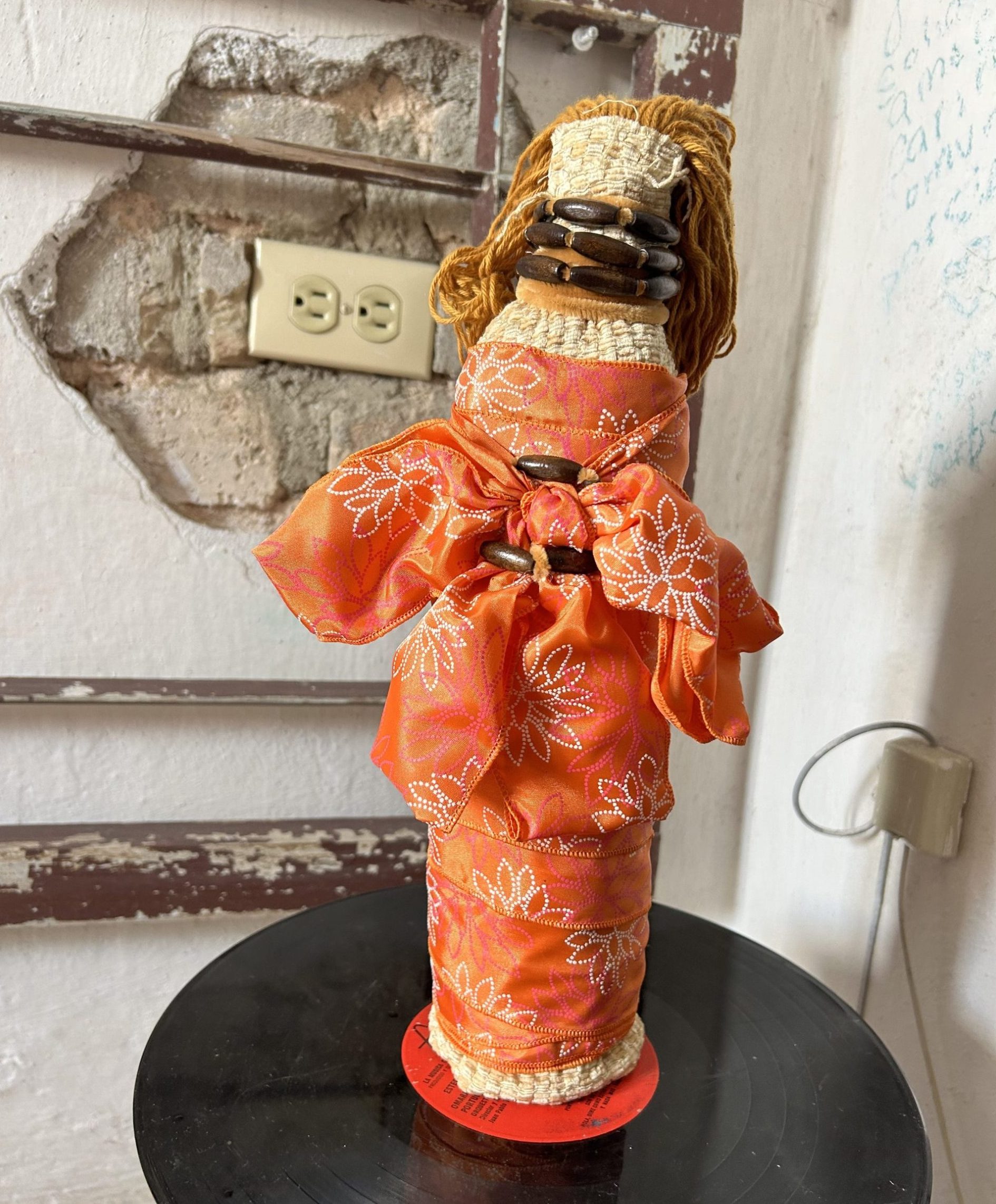 Black doll with orange dress with white pattern